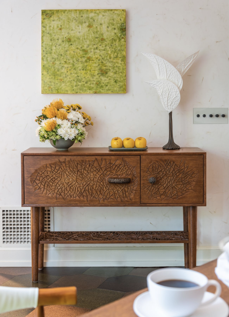 Taking a page out of modern mid-century design and melding it with a healthy dose of organic Arts & Crafts, the CarbonShack Mycelium Mod Console prominently features our signature mycelium motif: hand-carved onto the door fronts made of salvaged mahogany; 3D-printed as bronze hardware; and again as a lacey carved shelf suspended between the table's turned legs.