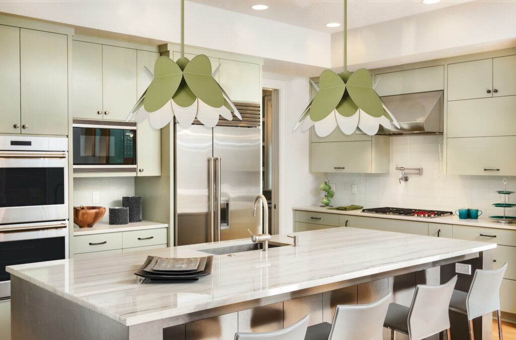Kitchen Interior with Island, Sink, Cabinets, Stainless Steel Refrigerator, Oven, and Hardwood Floors in New Luxury Home